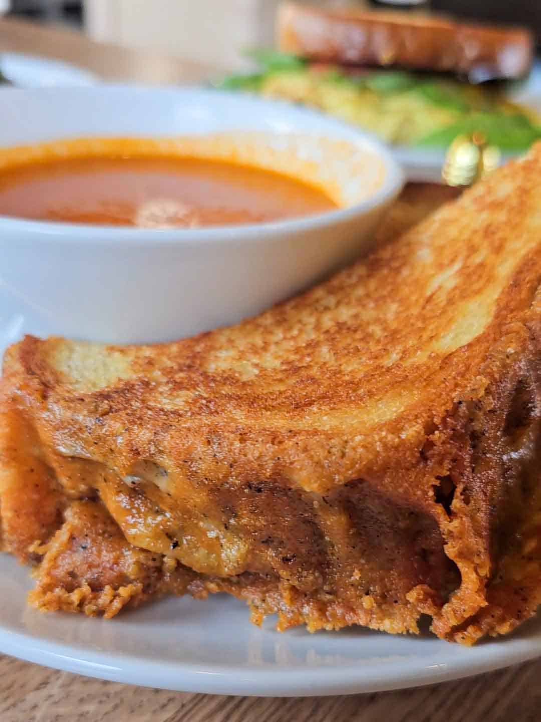 grilled cheese sandwich with a bowl of tomato soup