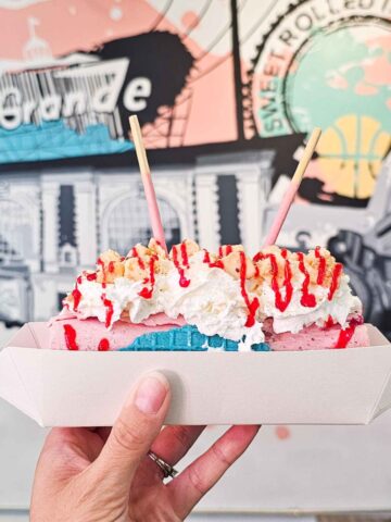 hand holding a rolled ice cream taco with a mural in the background