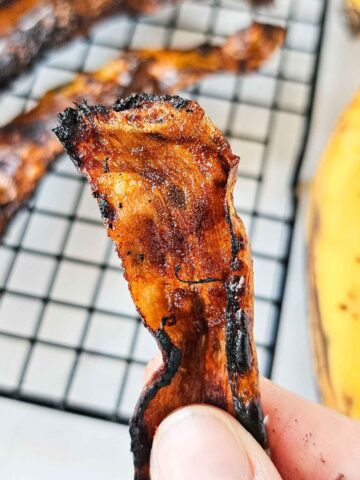 hand holding a slice of bacon